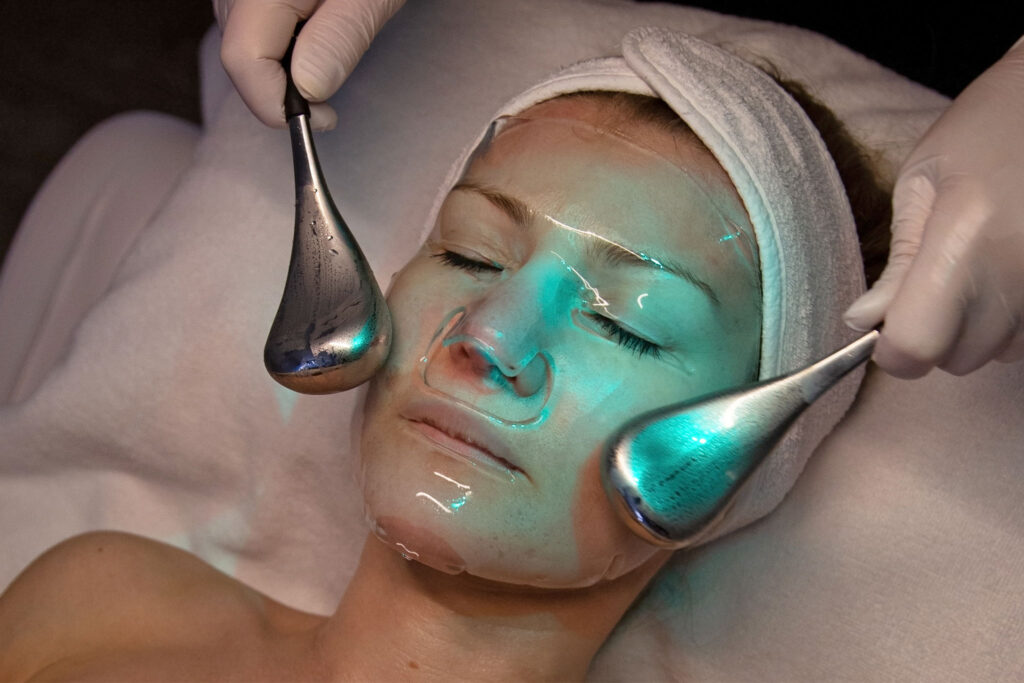 Kryo-Gesichtsbehandlung mit kühlenden Globes über einer transparenten Maske im Hautstudio Amy in Ravensburg